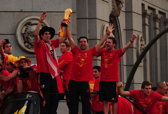 MADRID, SPAIN - JULY 12:  Xavi Hernandez holds aloft the FIFA World Cup to the crowds gathered in Plaza Cibeles on July 12, 2010 in Madrid, Spain after Spain won the FIFA World Cup.  (Photo by Denis Doyle/Getty Images)