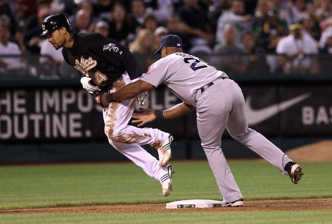 OAKLAND, CA - SEPTEMBER 10:  Coco Crisp #4 of the Oakland Athletics is tagged out by Adrian Beltre #29 of the Boston Red Sox after Crisp tried to reach third base after tagging up on a fly out to center field at the Oakland-Alameda County Coliseum on September 10, 2010 in Oakland, California.  (Photo by Ezra Shaw/Getty Images)