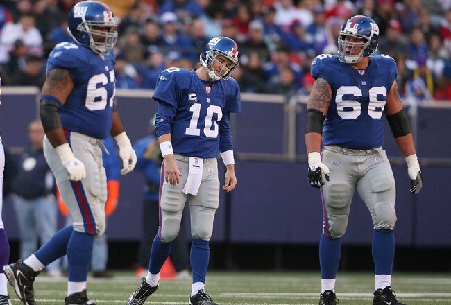 EAST RUTHERFORD, NJ - NOVEMBER 25:  Eli Manning #10 (c) of the New York Giants walks from the field after failing to make a first down against the Minnesota Vikings at Giants Stadium on November 25, 2007 in East Rutherford, New Jersey.  (Photo by Nick Laham/Getty Images)