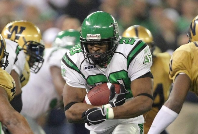 TORONTO - NOVEMBER 25:  Wes Cates #20 of the Saskatchewan Rough Riders tries to split the defense of Jerome Haywood #99 and Ike Charlton #10 of the Winnipeg Blue Bombers during the fourth quarter in the 95th Grey Cup on November 25, 2007 at the Rogers Centre in Toronto, Ontario, Canada.  The Rough Riders won 23-19.  (Photo by Harry How/Getty Images)