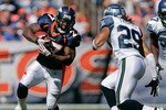 DENVER - SEPTEMBER 19:  Running back Knowshon Moreno #27 of the Denver Broncos runs through a hole as safety Earl Thomas #29 of the Seattle Seahawks looks to make a tackle during NFL action at INVESCO Field at Mile High on September 19, 2010 in Denver, Colorado.  (Photo by Justin Edmonds/Getty Images)