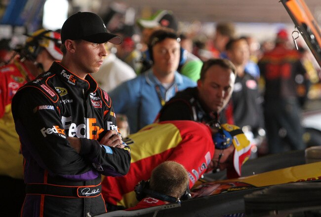 DOVER, DE - SEPTEMBER 25:  Denny Hamlin (L), driver of the #11 FedEx Express Toyota, and Kevin Harvick, driver of the #29 Shell/Pennzoil Chevrolet, look over their cars in the garage after an incident on track during practice for the NASCAR Sprint Cup Series AAA 400 at Dover International Speedway on September 25, 2010 in Dover, Delaware.  (Photo by Nick Laham/Getty Images)