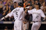 DENVER - SEPTEMBER 25:  Troy Tulowitzki #2 of the Colorado Rockies is welcomed home by Carlos Gonzalez #5 who scored on his two run homerun to give the Rockies a 5-4 lead over the San Francisco Giants in the fifth inning at Coors Field on September 25, 2010 in Denver, Colorado.  (Photo by Doug Pensinger/Getty Images)