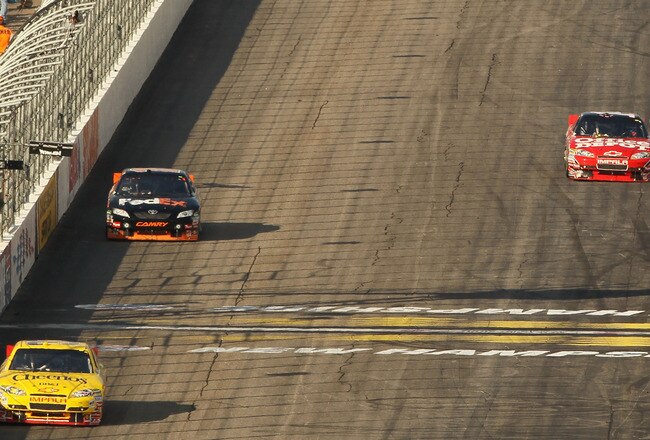 LOUDON, NH - SEPTEMBER 19:  Clint Bowyer, driver of the #33 Cheerios/Hamburger Helper Chevrolet, takes the white flag ahead of Denny Hamlin, driver of the #11 FedEx Small Business Toyota as Tony Stewart, driver of the #14 Office Depot/Old Spice Chevrolet runs out of gas during the NASCAR Sprint Cup Series Sylvania 300 at New Hampshire Motor Speedway on September 19, 2010 in Loudon, New Hampshire.  (Photo by Elsa/Getty Images)