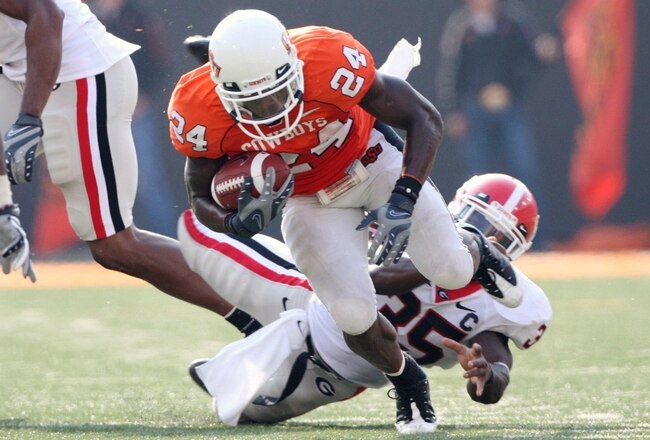 STILLWATER, OK - SEPTEMBER 5: Running back Kendall Hunter #24 of the Oklahoma State Cowboys carries the ball six yards as Rennie Curran #35 of the Georgia Bulldogs tries to stop him during the fourth quarter of the game at Boone Pickens Stadium on September 5, 2009 in Stillwater, Oklahoma. Oklahoma State won the game 24-10. (Photo by Christian Petersen/Getty Images)