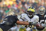 SOUTH BEND, IN - SEPTEMBER 11: Denard Robinson #16 of the Michigan Wolverines pushes off a tackle attempt by Manti Te'o #5 of the Notre Dame Fighting Irish in the final minute at Notre Dame Stadium on September 11, 2010 in South Bend, Indiana. Michigan defeated Notre Dame 28-24. (Photo by Jonathan Daniel/Getty Images)