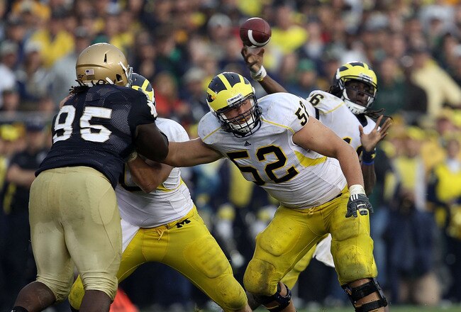 SOUTH BEND, IN - SEPTEMBER 11: Stephen Schilling #52 of the Michigan Wolverines blocks for quarterback Denard Robinson #16 as Ian Williams #95 of the Notre Dame Fighting Irish rushes at Notre Dame Stadium on September 11, 2010 in South Bend, Indiana. Michigan defeated Notre Dame 28-24. (Photo by Jonathan Daniel/Getty Images)