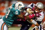 MIAMI - OCTOBER 04:  Quarterback Tom Brady #12 of the New England Patriots is preasures by linebacker Cameron Wake #91 of the Miami Dolphins at Sun Life Stadium on October 4, 2010 in Miami, Florida.  (Photo by Marc Serota/Getty Images)