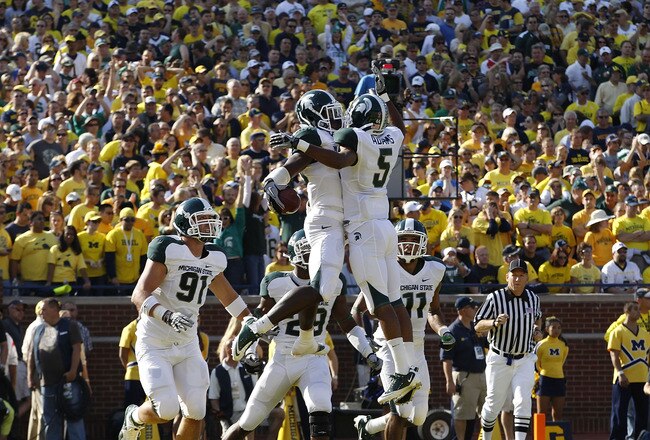 ANN ARBOR, MI - OCTOBER 09:  Chris Rucker #29 of the Michigan State Spartans celebrate with his teammates after intercepting Denard Robinson #16 of the Michigan Wolverines during the fourth quarter of the game on October 9, 2010 at Michigan Stadium in Ann Arbor, Michigan. The Michigan Spartans defeated the Michigan Wolverines 34-17  (Photo by Leon Halip/Getty Images)