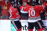 CHICAGO - JUNE 06: Dustin Byfuglien #33 and Patrick Sharp #10 of the Chicago Blackhawks celebrate scoring a goal against the Philadelphia Flyers in Game Five of the 2010 NHL Stanley Cup Final at the United Center on June 6, 2010 in Chicago, Illinois.  (Photo by Bruce Bennett/Getty Images)