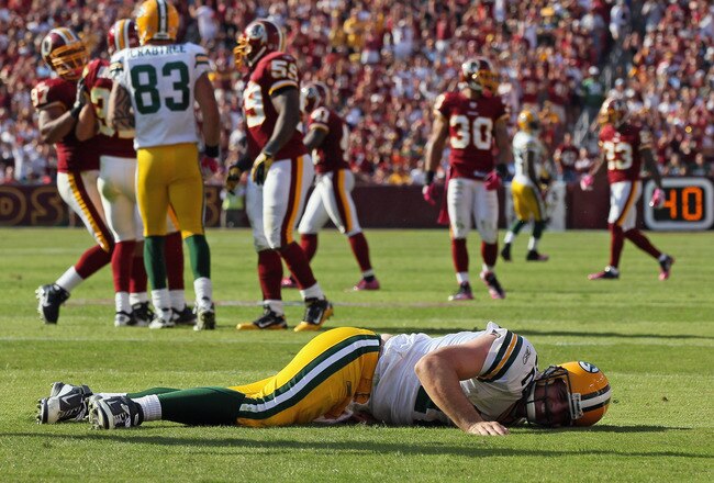 LANDOVER, MD - OCTOBER 10:  Aaron Rodgers #12 of the Green Bay Packers lays on the ground after a hard hit against the Washington Redskins in the fourth quarter at FedExField on October 10, 2010 in Landover, Maryland. The Redskins won the game in overtime 16-13.  (Photo by Win McNamee/Getty Images)