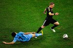PORT ELIZABETH, SOUTH AFRICA - JULY 10: Bastian Schweinsteiger of Germany is tackled by Edinson Cavani of Uruguay during the 2010 FIFA World Cup South Africa Third Place Play-off match between Uruguay and Germany at The Nelson Mandela Bay Stadium on July 10, 2010 in Port Elizabeth, South Africa.  (Photo by Jamie McDonald/Getty Images)
