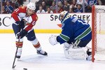 VANCOUVER, CANADA - OCTOBER 11: Cory Stillman #61 of the Florida Panthers tries to get a handle on the loose puck while goalie Roberto Luongo #1 of the Vancouver Canucks scrambles to get back into position during the first period in NHL action on October 11, 2010 at Rogers Arena in Vancouver, British Columbia, Canada.  (Photo by Rich Lam/Getty Images)