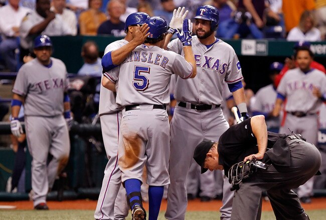 ST. PETERSBURG, FL - OCTOBER 12:  Infielder Ian Kinsler #5 of the Texas Rangers is congratulated at home plater by Nelson Cruz #17 (left) and Jeff Francoeur #21 after his home run against the Tampa Bay Rays during Game 5 of the ALDS at Tropicana Field on October 12, 2010 in St. Petersburg, Florida.  (Photo by J. Meric/Getty Images)