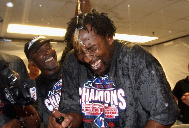 OAKLAND, CA - SEPTEMBER 25:  Vladimir Guerrero #27 of the Texas Rangers is covered in champagne by Gary Pettis after they beat the Oakland Athletics to clinch the American League West Title at the Oakland-Alameda County Coliseum on September 25, 2010 in Oakland, California.  (Photo by Ezra Shaw/Getty Images)