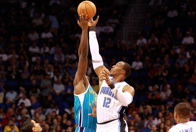 ORLANDO, FL - OCTOBER 10:  Dwight Howard #12 of the Orlando Magic jumps against  Emeka Okafor #50 of the New Orleans Hornets during the game at Amway Arena on October 10, 2010 in Orlando, Florida. NOTE TO USER: User expressly acknowledges and agrees that, by downloading and or using this Photograph, user is consenting to the terms and conditions of the Getty Images License Agreement.  (Photo by Sam Greenwood/Getty Images)