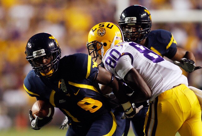 BATON ROUGE, LA - SEPTEMBER 25: Keith Tandy #8  of the West Virginia Mountaineers is tackled after intercepting the ball by Terrence Toliver #80  of the Louisiana State Univeristy Tigers at Tiger Stadium on September 25, 2010 in Baton Rouge, Louisiana.  (Photo by Chris Graythen/Getty Images)