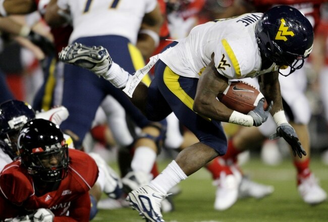 CINCINNATI - NOVEMBER 13:  Runningback Noel Devine #7 of the West Virginia Mountaineers is taken down in the third quarter of the game against the Cincinnati Bearcats in at Nippert Stadium on November 13, 2009 in Cincinnati, Ohio.  (Photo by Andy Lyons/Getty Images)