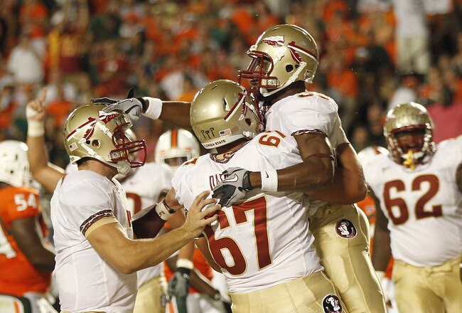 MIAMI, FL - OCTOBER 9: Jermaine Thomas #38 pats Christian Ponder #7 on the head as he is held by Andrew Datko #67 of the Florida State Seminoles after scoring a touchdown against the Miami Hurricanes on October 9, 2010 at Sun Life Stadium in Miami, Florida. The Seminoles defeated the Hurricanes 45-17. (Photo by Joel Auerbach/Getty Images)