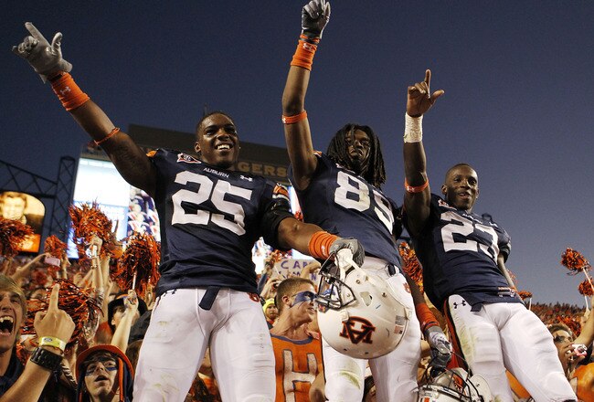 AUBURN - OCTOBER 16:  Linebacker Daren Bates #25, wide receiver Darvin Adams #89 and running back Onterio McCalebb #23 of the Auburn Tigers celebrate with the crowd after the game against the Arkansas Razorbacks at Jordan-Hare Stadium on October 16, 2010 in Auburn, Alabama.  The Tigers beat the Razorbacks 65-43.  (Photo by Mike Zarrilli/Getty Images)