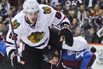 DENVER, CO - OCTOBER 7: Adam Foote #52 of the Colorado Avalanche gets tangled up with Tomas Kopecky #82 of the Chicago Blackhawks during a scrum in front of the net during both team's season openers at the Pepsi Center on October 7, 2010 in Denver, Colorado. (Photo by Marc Piscotty/Getty Images)