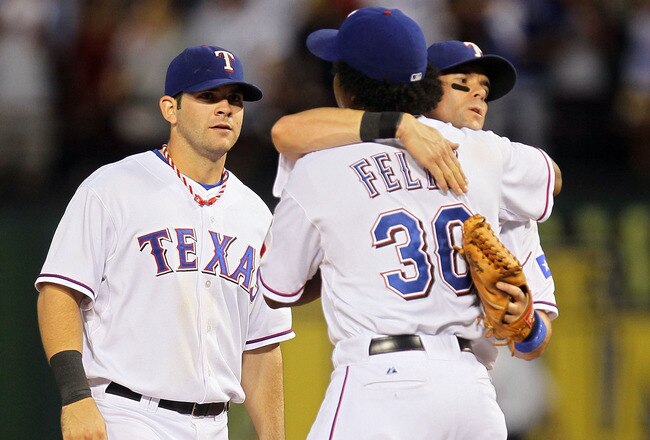ARLINGTON, TX - OCTOBER 16:  Neftali Feliz #30, Michael Young #10 and Mitch Moreland #18 of the Texas Rangers celebrate after defeating the New York Yankees by a score of 7-2 to win Game Two of the ALCS during the 2010 MLB Playoffs at Rangers Ballpark in Arlington on October 16, 2010 in Arlington, Texas.  (Photo by Stephen Dunn/Getty Images)