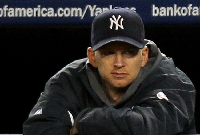 NEW YORK - OCTOBER 18:  (L-R)   A.J. Burnett #34 and Ramiro Pena #19 of the New York Yankees look on from the bench late in the game against the Texas Rangers in Game Three of the ALCS during the 2010 MLB Playoffs at Yankee Stadium on October 18, 2010 in New York, New York. The Rangers won 8-0. (Photo by Nick Laham/Getty Images)