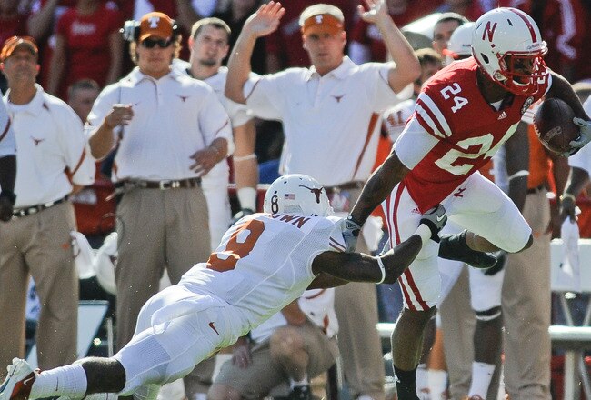 LINCOLN, NE - OCTOBER 16:  Wide receiver Niles Paul #24 of the Nebraska Cornhuskers tries to slip the grip defensive end Dravannti Johnson #9 of the Texas Longhorns during first half action of their game at Memorial Stadium on October 16, 2010 in Lincoln, Nebraska. Texas Defeated Nebraska 20-13. (Photo by Eric Francis/Getty Images)