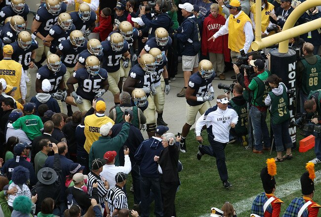 SOUTH BEND, IN - SEPTEMBER 25: Head coach Brian Kelly of the Notre Dame Fighting Irish leads his team onto the field before taking on the Stanford Cardinal at Notre Dame Stadium on September 25, 2010 in South Bend, Indiana. Stanford defeated Notre Dame 37-14. (Photo by Jonathan Daniel/Getty Images)