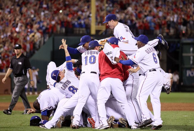 ARLINGTON, TX - OCTOBER 22:  Josh Hamilton #32 of the Texas Rangers dives on the pile as he celebrates with his teammates after the Rangers won 6-1 against the New York Yankees in Game Six of the ALCS during the 2010 MLB Playoffs at Rangers Ballpark in Arlington on October 22, 2010 in Arlington, Texas.  (Photo by Elsa/Getty Images)