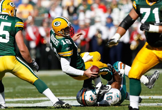 GREEN BAY, WI - OCTOBER 17: Aaron Rogers #12 of the Green Bay Packers is sacked by Cameron Wake #91 of the Miami Dolphins at Lambeau Field on October 17, 2010 in Green Bay, Wisconsin. (Photo by Scott Boehm/Getty Images)