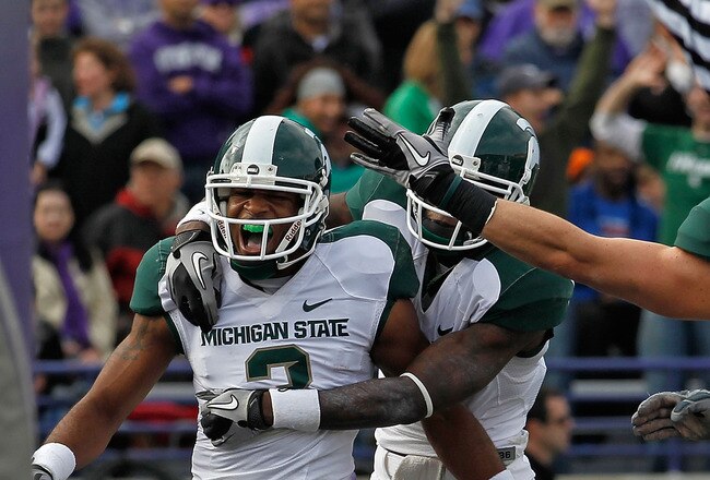 EVANSTON, IL - OCTOBER 23: B.J. Cunningham #3 of the Michigan State Spartans gets a hug from teammate Mark Dell #2 after catching a touchdown pass against the Northwestern Wildcats at Ryan Field on October 23, 2010 in Evanston, Illinois. Michigan State defeated Northwestern 35-27. (Photo by Jonathan Daniel/Getty Images)
