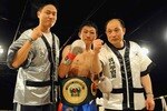 KEMPTON PARK, SOUTH AFRICA - SEPTEMBER 12:  Ji Hoon Kim (blue trunks) celebrates with his trainers during the IBO Super Featherweight Title match between Zolani Marali and Ji Hoon Kim from Emperors Palace on September 12, 2009 in Kempton Park, South Africa.  (Photo by Lee Warren/Gallo Images/Getty Images)