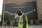 CLEVELAND - JULY 8:  A parking attendant stands near a larger than life photograph of LeBron James July 8, 2010 in Cleveland, Ohio. The two-time Most Valuable Player has the choice of remaining with the Cleveland Cavaliers or signing with a new team. (Photo by J.D. Pooley/Getty Images)
