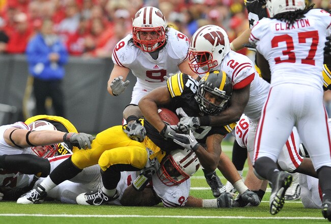 IOWA CITY, IA - OCTOBER 23- Running back Adam Robinson #32 of the University of Iowa Hawkeyes is tackled by defensive back Jay Valai #2 and linebacker Blake Sorensen #9 of the Wisconsin Badgers during the second half of play at Kinnick Stadium on October 23, 2010 in Iowa City, Iowa. Wisconsin won 31-30 over Iowa. (Photo by David Purdy/Getty Images)