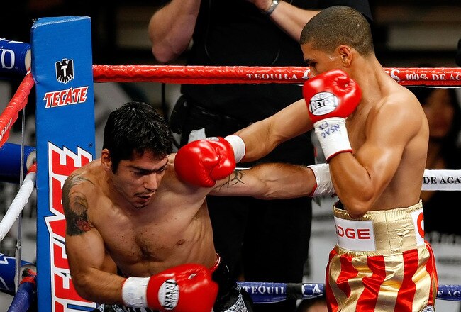 LAS VEGAS - DECEMBER 06:  (R-L) Juan Manuel Lopez of Puerto Rico connects a right to the head of Sergio Medina of Argentina during their WBO junior featherweight title fight at the MGM Grand Garden Arena December 6, 2008 in Las Vegas, Nevada.  (Photo by Ethan Miller/Getty Images)