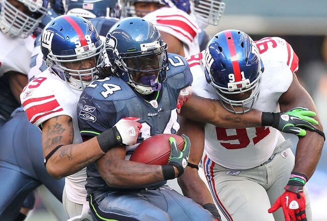 SEATTLE - NOVEMBER 07:  Running back Marshawn Lynch #24 of the Seattle Seahawks is tackled by Michael Boley #59 and defensive end Justin Tuck #91 of the New York Giants at Qwest Field on November 7, 2010 in Seattle, Washington. The Giants defeated the Seahawks 41-7. (Photo by Otto Greule Jr/Getty Images)