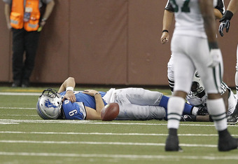 DETROIT - NOVEMBER 07: Matthew Stafford #9 of the Detroit Lions lays on the ground holding his right shoulder after being sacked by Bryan Thomas #58 of the New York Jets during the third quarter of the game at Ford Field on November 7, 2010 in Detroit, Michigan. The Jets defeated the Lions 23-20 in overtime.  (Photo by Leon Halip/Getty Images)