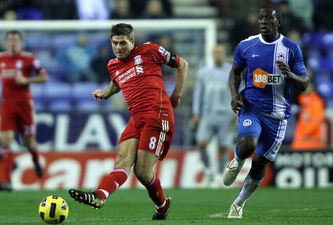 WIGAN, ENGLAND - NOVEMBER 10:  Steven Gerrard of Liverpool passes the ball away from Hendry Thomas of Wigan Athletic during the Barclays Premier League match between Wigan Athletic and Liverpool at DW Stadium on November 10, 2010 in Wigan, England.  (Photo by Clive Brunskill/Getty Images)
