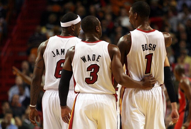 MIAMI - NOVEMBER 06: Dwyane Wade #3, LeBron James #6 and Chris Bosh #1 of the Miami Heat chat during a game against the New Jersey Nets  at American Airlines Arena on November 6, 2010 in Miami, Florida. NOTE TO USER: User expressly acknowledges and agrees that, by downloading and or using this photograph, User is consenting to the terms and conditions of the Getty Images License Agreement.  (Photo by Marc Serota/Getty Images)