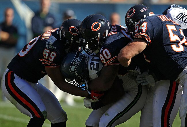 CHICAGO - OCTOBER 17: Justin Forsett #20 of the Seattle Seahawks is tackled by (L-R) Pia Tinoisamoa #59, Julius Peppers #90 and Brian Urlacher #54 of the Chicago Bears at Soldier Field on October 17, 2010 in Chicago, Illinois. The Seahawks defeated the Bears 23-20. (Photo by Jonathan Daniel/Getty Images)