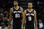 CHARLOTTE, NC - NOVEMBER 08:  Teammates Tony Parker #9 and Tim Duncan #21 of the San Antonio Spurs walk onto the court against the Charlotte Bobcats before their game at Time Warner Cable Arena on November 8, 2010 in Charlotte, North Carolina.  NOTE TO USER: User expressly acknowledges and agrees that, by downloading and/or using this Photograph, User is consenting to the terms and conditions of the Getty Images License Agreement.  (Photo by Streeter Lecka/Getty Images)