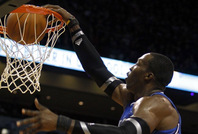 MIAMI - OCTOBER 29:  Center Dwight Howard #12  of the Orlando Magic dunks against forward Chris Bosh #1 of the Miami Heat at American Airlines Arena on October 29, 2010 in Miami, Florida.  NOTE TO USER: User expressly acknowledges and agrees that, by downloading and or using this photograph, User is consenting to the terms and conditions of the Getty Images License Agreement. (Photo by Marc Serota/Getty Images)