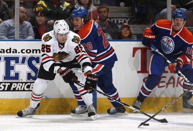 EDMONTON, CANADA - NOVEMBER 17:  Viktor Stalberg #25 of the Chicago Blackhawks is checked by Ryan Jones #28 of the Edmonton Oilers in third-period action. Chicago won the game 5-0 at Rexall Place November 17, 2010 in Edmonton, Alberta, Canada. (Photo by Dale MacMillan/Getty Images)