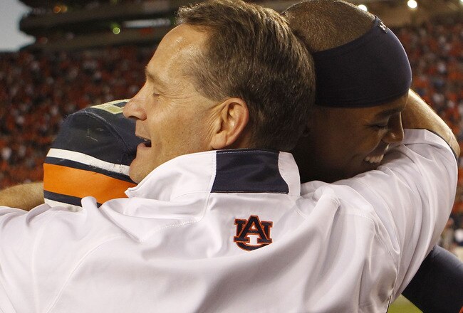 AUBURN - OCTOBER 16:  Head coach Gene Chizik of the Auburn Tigers hugs quarterback Cam Newton #2 after the game against the Arkansas Razorbacks at Jordan-Hare Stadium on October 16, 2010 in Auburn, Alabama.  The Tigers beat the Razorbacks 65-43.  (Photo by Mike Zarrilli/Getty Images)