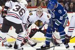 VANCOUVER, CANADA - NOVEMBER 20: Goalie Corey Crawford #50 of the Chicago Blackhawks watches Henrik Sedin #33 of the Vancouver Canucks and Dave Bolland #36 of the Blackhawks battle for the loose puck during the first period in NHL action on November 20, 2010 at Rogers Arena in Vancouver, British Columbia, Canada.  (Photo by Rich Lam/Getty Images)