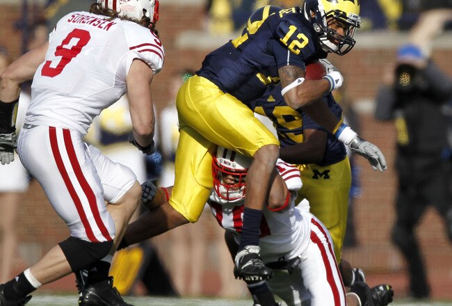 ANN ARBOR, MI - NOVEMBER 20:  Roy Roundtree #12 of the Michigan Wolverines tries to split the tackles of Devin Smith #10 and Blake Sorensen #9 of the Wisconsin Badgers at Michigan Stadium on November 20, 2010 in Ann Arbor, Michigan. Wisconson won the game 48-28.  (Photo by Gregory Shamus/Getty Images)