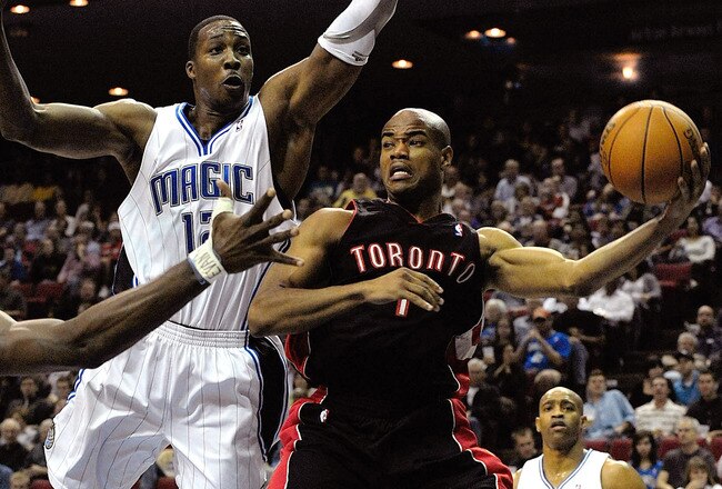 ORLANDO, FL - DECEMBER 16:  Jarrett Jack #1 of the Toronto Raptors looks to pass against Dwight Howard #12 of the Orlando Magic during the game at Amway Arena on December 16, 2009 in Orlando, Florida.  NOTE TO USER: User expressly acknowledges and agrees that, by downloading and/or using this Photograph, user is consenting to the terms and conditions of the Getty Images License Agreement.  (Photo by Sam Greenwood/Getty Images)