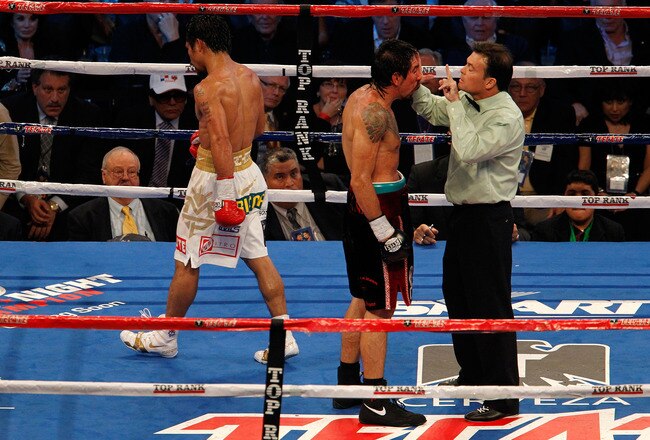 ARLINGTON, TX - NOVEMBER 13:  Referee Laurence Cole inspects the cut on the eye of Antonio Margarito (black trunks) of Mexico as Manny Pacquiao (white trunks) of the Philippines looks on during their WBC World Super Welterweight Title bout at Cowboys Stadium on November 13, 2010 in Arlington, Texas.  (Photo by Tom Pennington/Getty Images)
