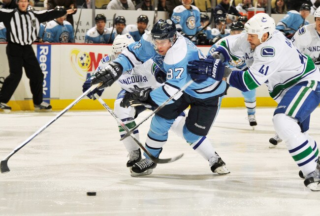 PITTSBURGH - NOVEMBER 17:  Sidney Crosby #87 of the Pittsburgh Penguins loses control of the puck as he attempts to split the defense of Keith Ballard #4 of the Vancouver Canucks and Andrew Alberts #41 of the Vancouver Canucks on November 17, 2010 at Consol Energy Center in Pittsburgh, Pennsylvania.  (Photo by Jamie Sabau/Getty Images)